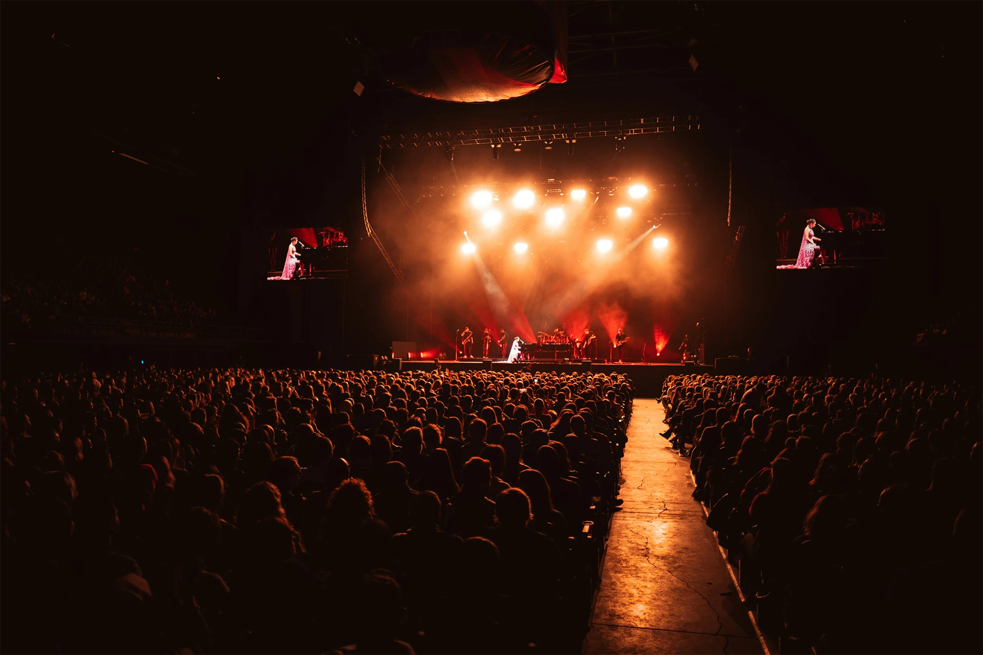 Concierto de noche con el escenario de fondo y con mucho público